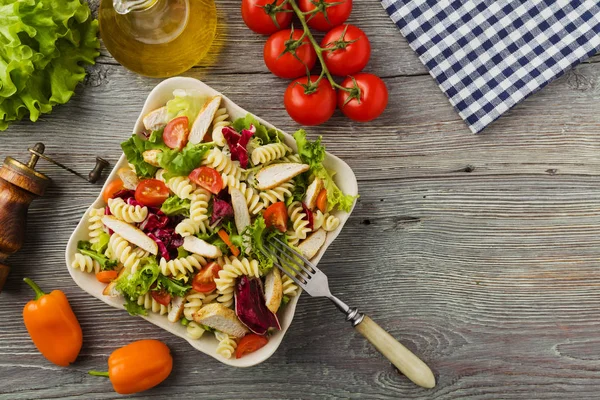 Nudelsalat mit grünem Salat, Tomaten und gebratenem Huhn. — Stockfoto