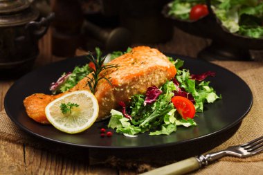 Fırında somon taze sebzelerle servis edilir..