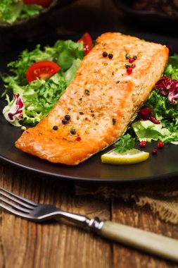 Fırında somon taze sebzelerle servis edilir..