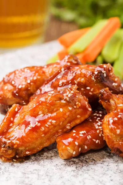 Baked chicken wings in honey sauce sprinkled with sesame seeds.