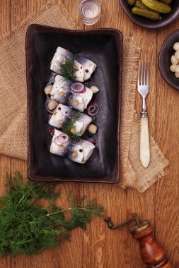 Sirke de haddelenmiş ringa, soğan ve turşu ile servis. 