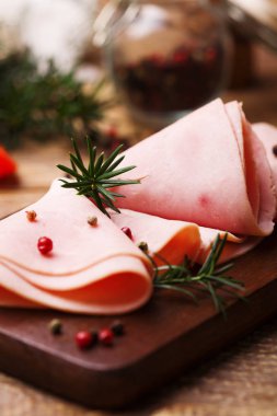 Baharatlar ile ahşap bir tahta üzerinde lezzetli pişmiş jambon.