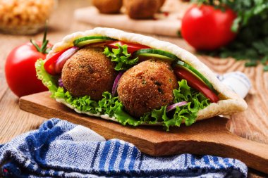 Falafel ve taze sebzeler ahşap masada pide