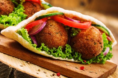 Falafel ve taze sebzeler ahşap masada pide