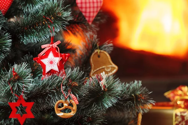 Na stromě visely vánoční ozdoby. Hořící krb v — Stock fotografie