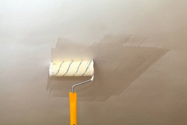 Tavanı beyaz boya ile bir rulo boyama.