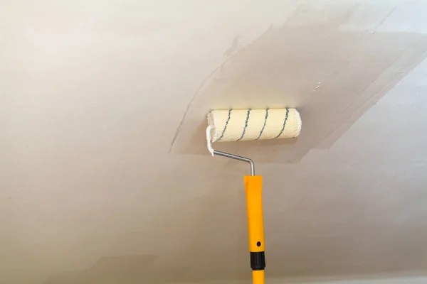 Pintura del techo un rodillo con pintura blanca . —  Fotos de Stock