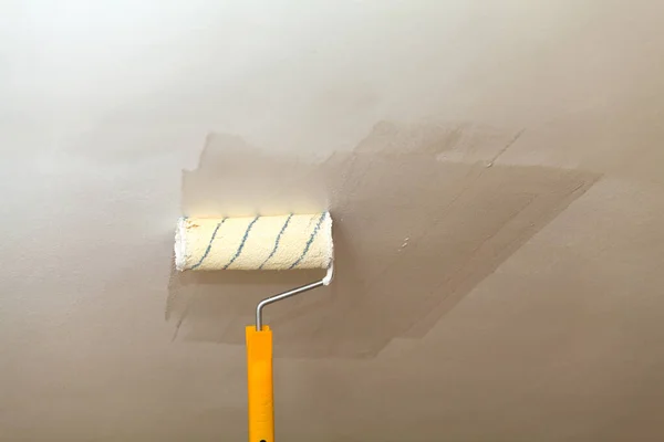 Peindre le plafond un rouleau avec de la peinture blanche . — Photo