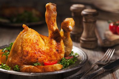 Fırında tavuk budu, kızarmış patates ve sebzeyle servis edilir..