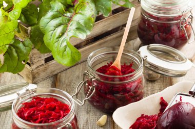 Kavanozda marine edilmiş rendelenmiş pancar kökü. Ahşap arkaplan.