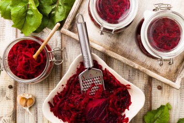 Kavanozda marine edilmiş rendelenmiş pancar kökü. Ahşap arkaplan.