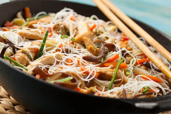 Rice noodles with chicken, mushrooms mun and vegetables in wook. — Stock Photo, Image