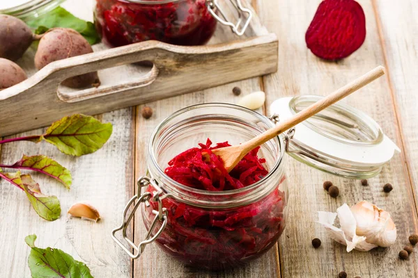 Geriebene Rote Bete mariniert in Gläsern. Hölzerner Hintergrund. — Stockfoto