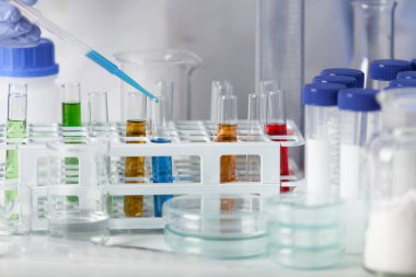 Laboratuvar. Beyaz önlüklü ve lastik eldivenli laboratuvar teknisyeni test örneklerini analiz ediyor..