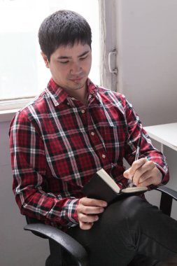 Genç adam not alıyor.