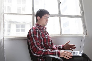 Genç adam dizüstü bilgisayar kullanıyor 