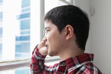 Genç adam telefonda konuşuyor.