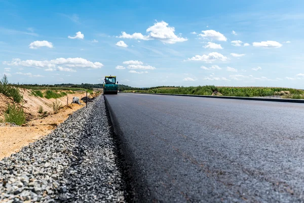 Rodillo de carretera trabajando en el sitio de construcción — Foto de Stock