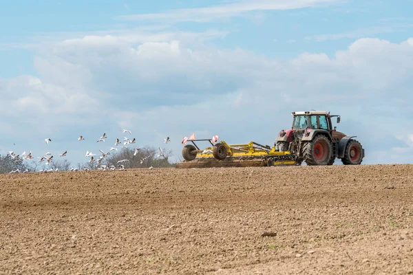 Tractor harrowing the field — Stock Photo, Image