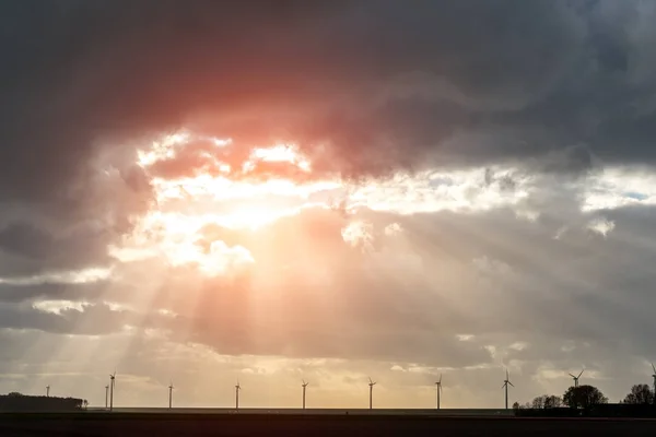 Pôr do sol sobre os moinhos de vento no campo — Fotografia de Stock