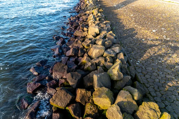 Bloques de piedra entre el mar y la carretera — Foto de Stock