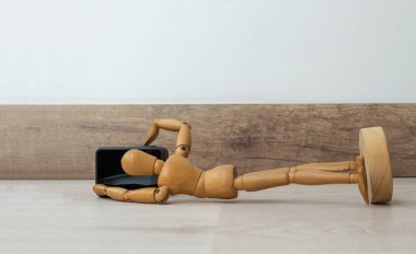 Tahta bebek yerde yatıp fotoğraf çekiyor.