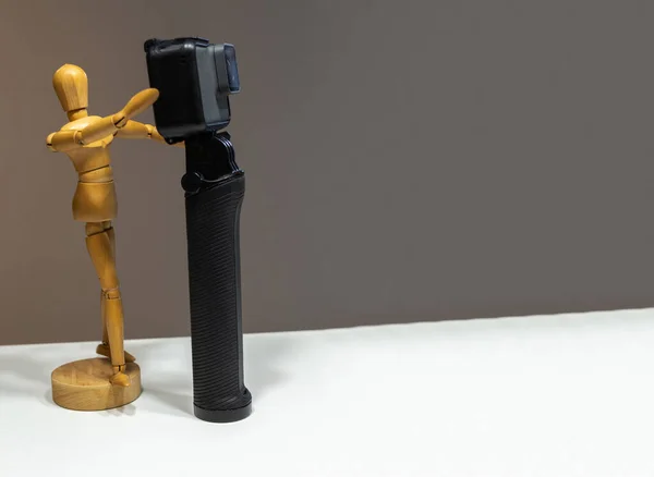 Wooden dummy with a photo and video camera on a brown background