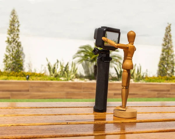 Wooden dummy with photo and video camera in a garden