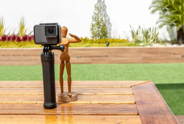 Wooden dummy on a deck in the middle of a park with photo and video camera