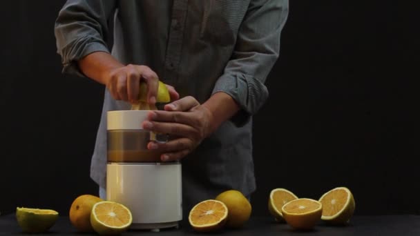 Person Squeezing Oranges Machine Black Background — Stock Video