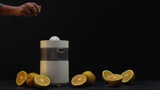 オレンジジュースを作る手でジューサーのクローズアップ — ストック動画