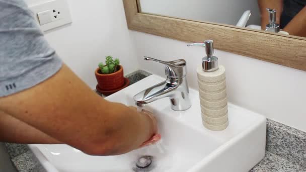 白いバスルームで手を洗うために液体石鹸を服用する人の45度かかります — ストック動画
