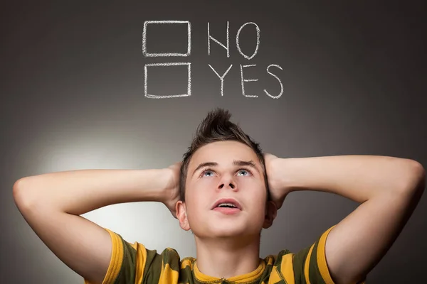 Young boy looking up at Yes and No words Stock Picture