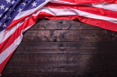 The American Flag Laying on a Wooden Background clipart