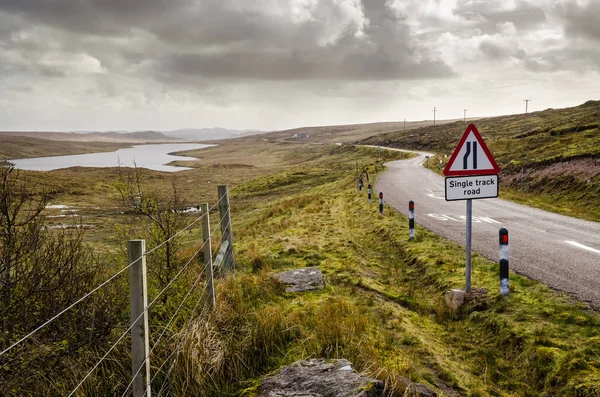 Yol dikkat levhası, tek parça yol. İskoç manzara. Scot