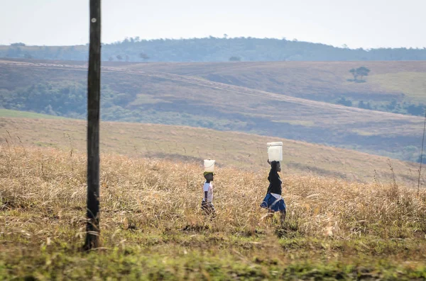 stock image African people wollking with buckets of water on their heads. South Africa