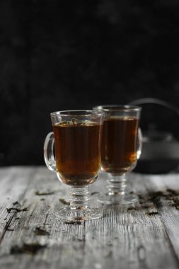 Bir cam fincan ahşap arka plan üzerinde siyah çay