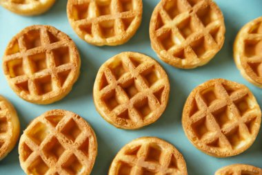 Mavi arka planda küçük yuvarlak Belçika waffle 'ları. Yemeği kapat, manzarayı izle.