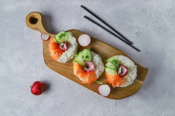 Taze sebzeli Asya yemeği suşi çörekleri. Vejetaryenler ve vejetaryenler için çağdaş atıştırmalıklar. Pirinç, havuç, salatalık ve simit şeklinde turp.