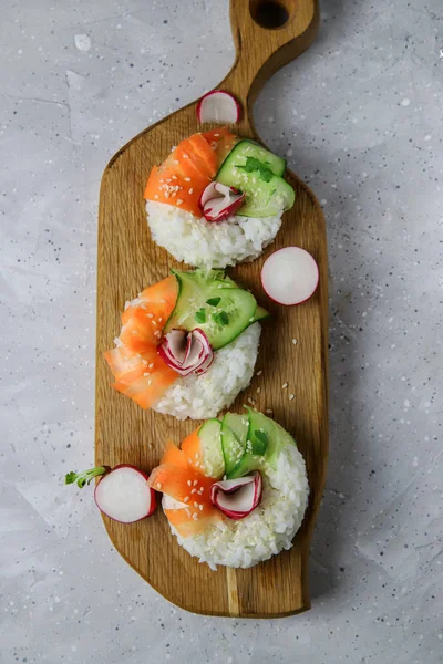 Taze sebzeli Asya yemeği suşi çörekleri. Vejetaryenler ve vejetaryenler için çağdaş atıştırmalıklar. Pirinç, havuç, salatalık ve simit şeklinde turp.