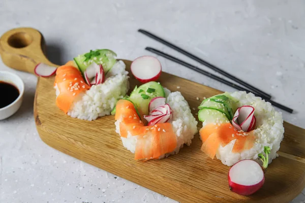 Taze sebzeli Asya yemeği suşi çörekleri. Vejetaryenler ve vejetaryenler için çağdaş atıştırmalıklar. Pirinç, havuç, salatalık ve simit şeklinde turp.