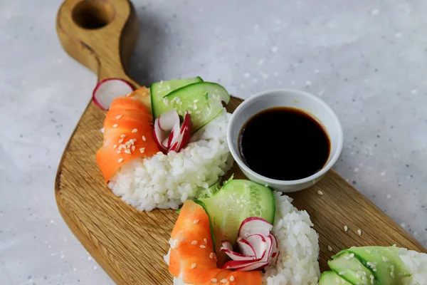 Taze sebzeli Asya yemeği suşi çörekleri. Vejetaryenler ve vejetaryenler için çağdaş atıştırmalıklar. Pirinç, havuç, salatalık ve simit şeklinde turp.