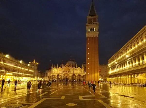 VENECIA, ITALIA - 15 de diciembre de 2019: Vista nocturna con personas caminando en una Plaza San Marco inundada durante la marea alta . —  Fotos de Stock