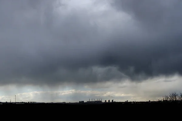 Thunderstorm over the city on a summer evening. Monstrous clouds over industrial buildings. Apocalyptic landscape. — Stock Photo, Image