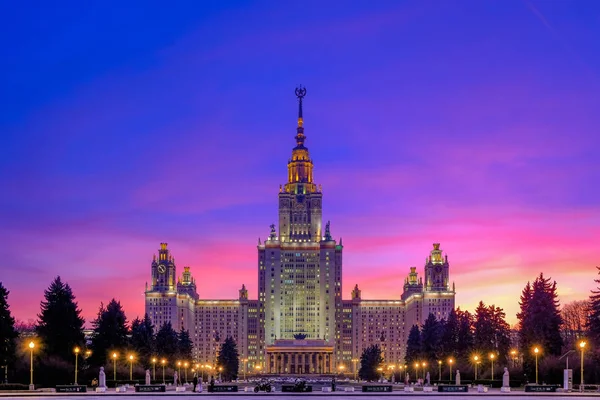 Μωβ ηλιοβασίλεμα ουρανό πάνω από το μεγαλοπρεπές κτίριο της εποχής του Στάλιν i — Φωτογραφία Αρχείου