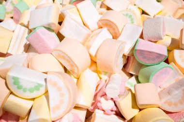 Karpuz yeşili, pembe, turuncu ve beyaz dilimler halinde lokum. Renkli tatlı arkaplan.