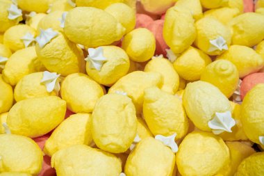 Büyük bir yığın parlak sarı şeker limonu. Lezzetli bir parça hamur işi. Parlak pasta arkaplanı.