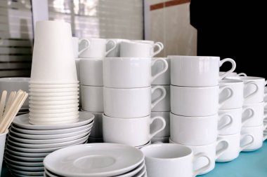Beyaz, temiz seramik bardaklar ve çay tabakları üzerinde korunmasız. Lokantadaki yemekler çay, içki ve kahve için hazırlandı..