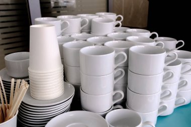 Beyaz, temiz seramik bardaklar ve çay tabakları üzerinde korunmasız. Çay ve kahve için restoranda bulaşıklar..