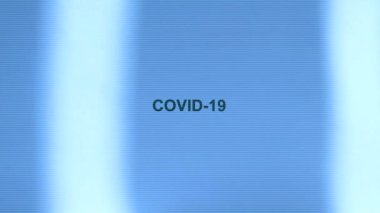 Mavi arka planda siyah COVID 19 yazılıydı. Işık şeritleri sağa sola hareket eder. 